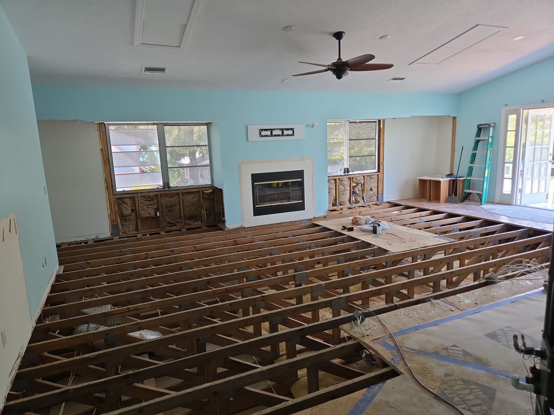 Living room floor gutted to the joists after water damage
